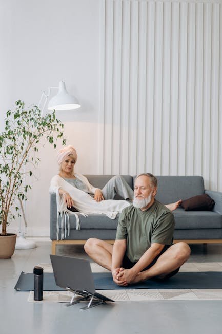 Calm woman doing a seated yoga pose on a mat in a bright, modern living room.