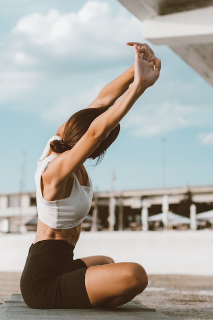 Woman stretching her arms and back gracefully outdoors.